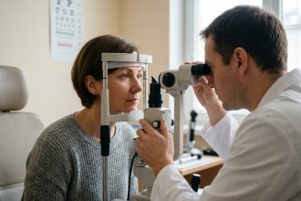 Femme de 45 ans lors d'un contrôle de la vue chez l'ophtalmologue, examen à la lampe à fente